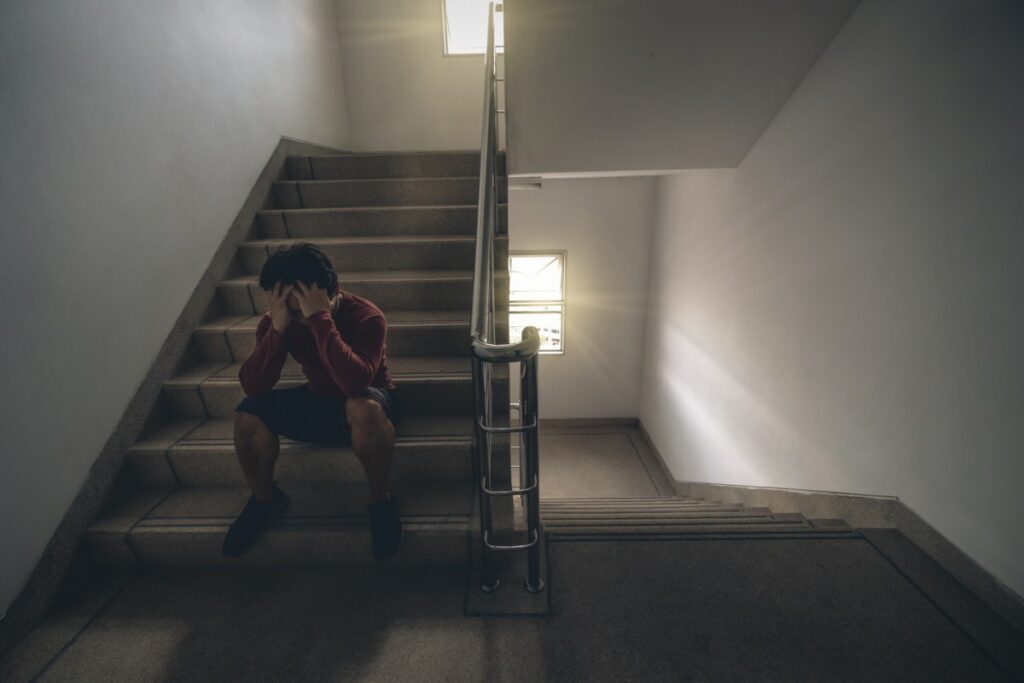 Homem depressivo sentado na escada.