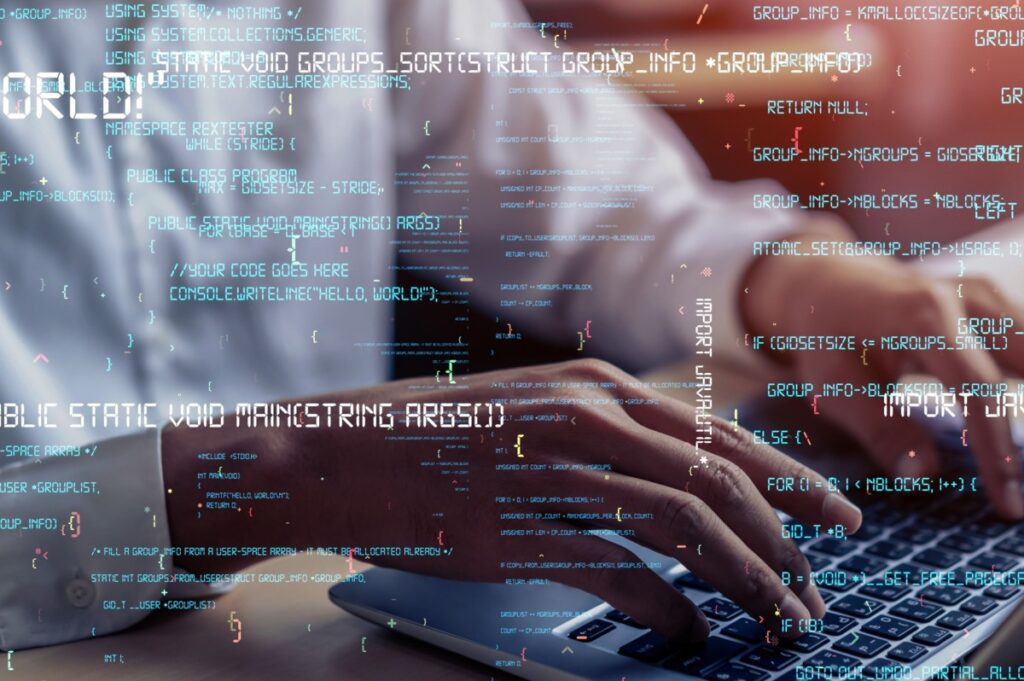 Homem digitando no computador com letras representando os algorítimos.