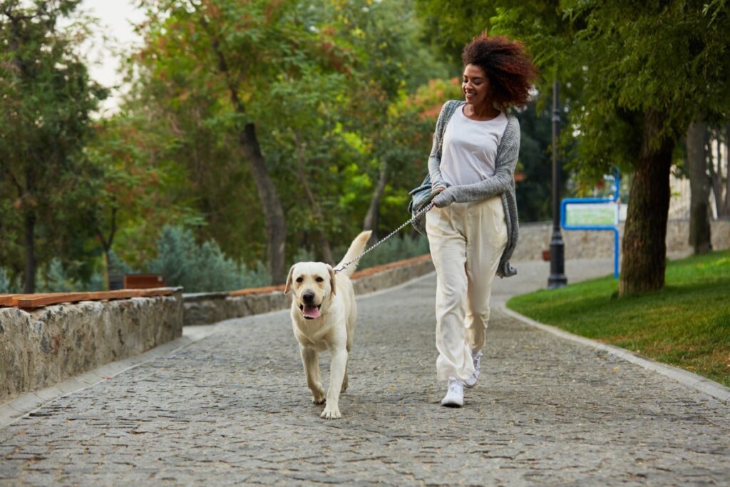 Mulher andando com seu cachorro.